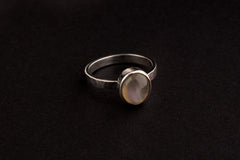 Purple Labradorite Silver Ring shown on black background with round cabochon and polished hammered silver setting.