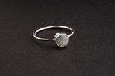 Handmade 925 sterling silver Lightning Ridge Black Opal ring shown on a dark background, with rough opal and fine silver band.