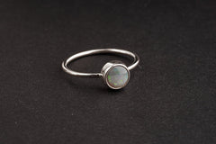 Handmade 925 sterling silver Lightning Ridge Black Opal ring shown on a dark background, with rough opal and fine silver band.