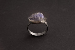 Raw Tanzanite Silver Ring shown on black background with upright blue-violet raw gemstone and fine silver band.
