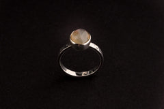 Purple Labradorite Silver Ring shown on black background with upright round gemstone and fine sterling silver band.