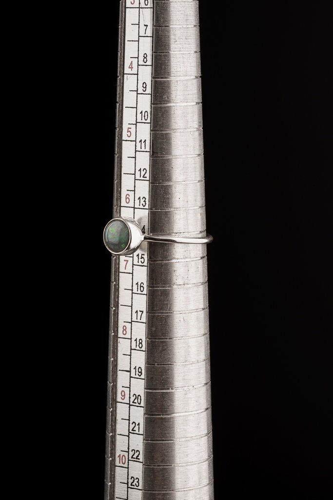 Lightning Ridge Black Opal ring shown on a mandrel for size reference, appearing around US size 6.5 to 7.