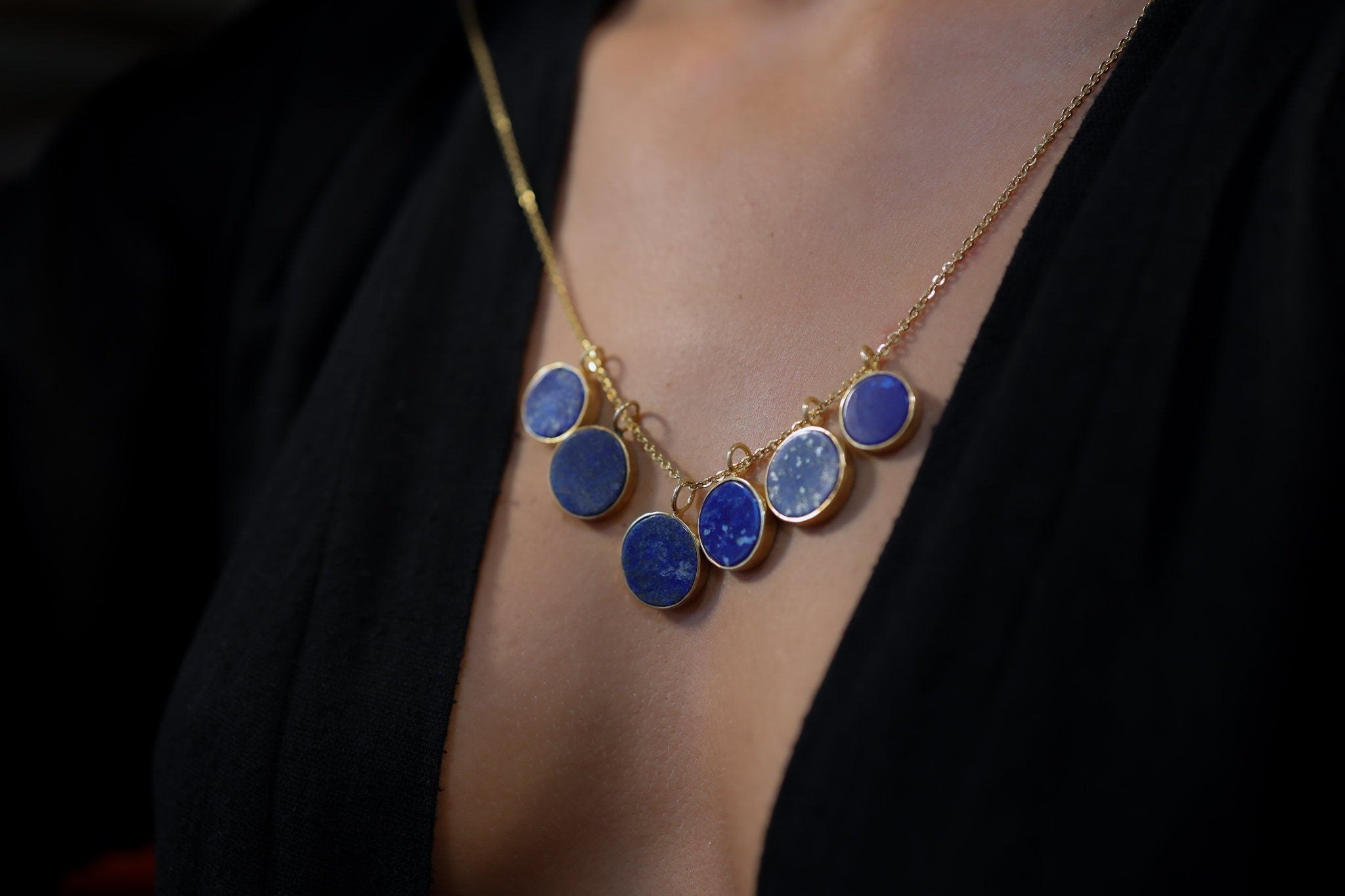 Gold-plated Lapis Lazuli pendant shown worn as part of a blue gemstone necklace, with deep royal blue stone and handmade silver setting.
