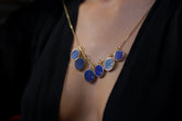 Gold-plated Lapis Lazuli pendant shown worn as part of a blue gemstone necklace, with deep royal blue stone and handmade silver setting.