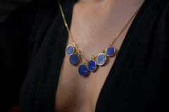 Gold-plated Lapis Lazuli pendant shown worn as part of a blue gemstone necklace, with deep royal blue stone and handmade silver setting.