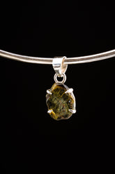 Verdelite Green Tourmaline pendant displayed on silver choker against black background.