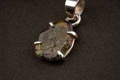 Close view of Green Tourmaline stone held in textured sterling silver claws.
