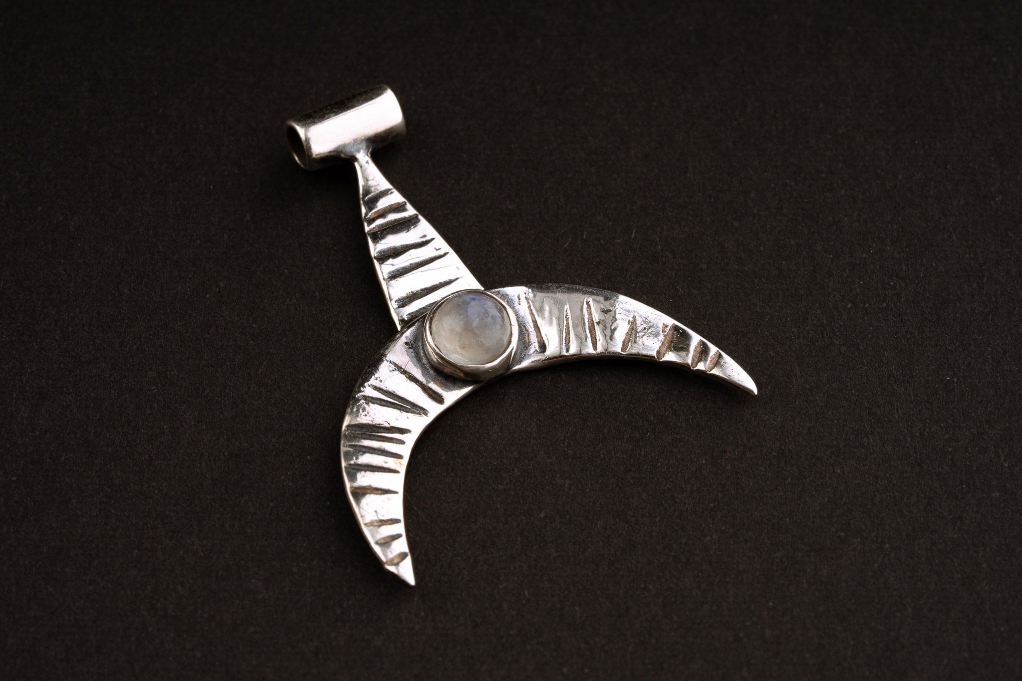 Crescent Whale Moonstone pendant shown on dark background with oxidized sterling silver and Blue Moonstone accent.