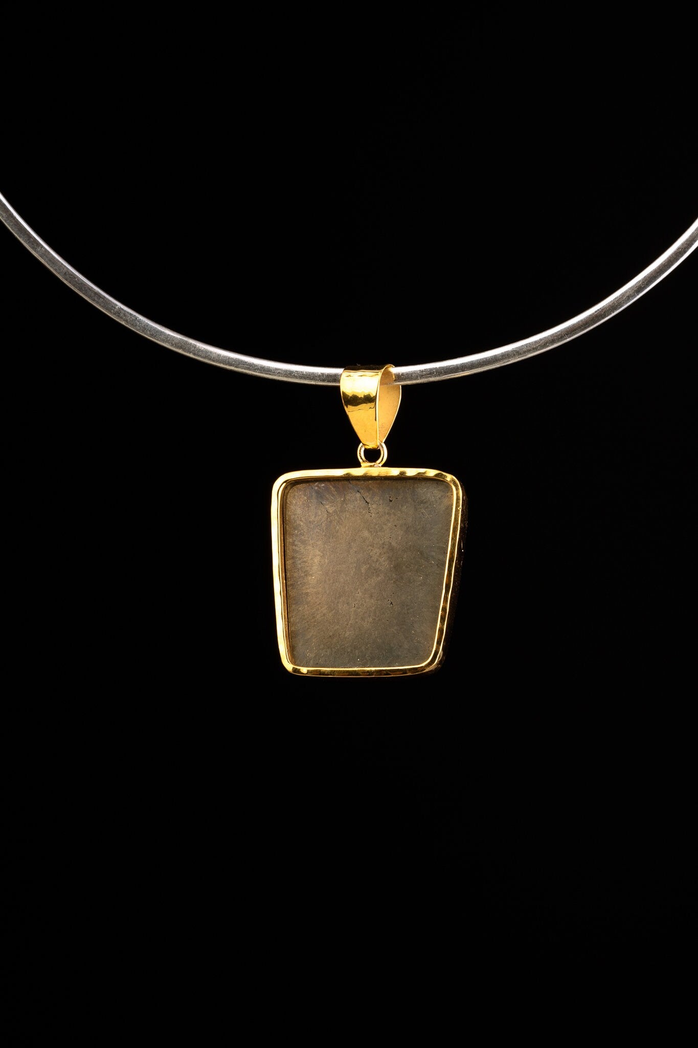 Gold-plated Cubic Pyrite pendant shown from the back on a necklace, with polished golden setting and sculptural bail.