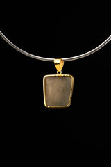 Gold-plated Cubic Pyrite pendant shown from the back on a necklace, with polished golden setting and sculptural bail.
