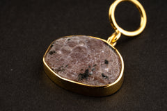 Close-up of raw Ruby record keeper pendant with gold-plated silver cap, wide bail, mica inclusions, and earthy red mineral texture.