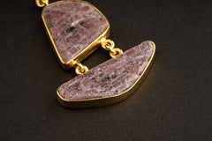 Detail view of two linked raw Ruby stones in 16k gold-plated sterling silver, showing earthy red colour and mineral inclusions.