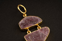 Close-up of double raw Indian Ruby pendant showing mica inclusions, dark trace minerals, gold-plated links, and textured stone surfaces.