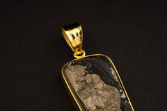 Close-up of gold-plated cubic Pyrite pendant showing hammered silver bezel, coiled bail, and raw metallic mineral surface.