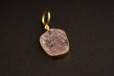 Raw Indian Ruby record keeper pendant with mica inclusions and 16k gold-plated sterling silver setting on a dark background.