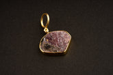 Raw Indian Ruby record keeper pendant with mica inclusions and 16k gold-plated sterling silver setting on a dark background.