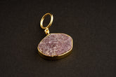Raw Indian Ruby pendant with mica inclusions and 16k gold-plated sterling silver setting, shown on a dark background.