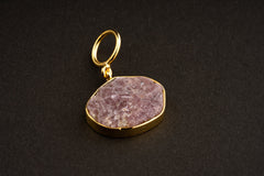 Raw Indian Ruby pendant with mica inclusions and 16k gold-plated sterling silver setting, shown on a dark background.