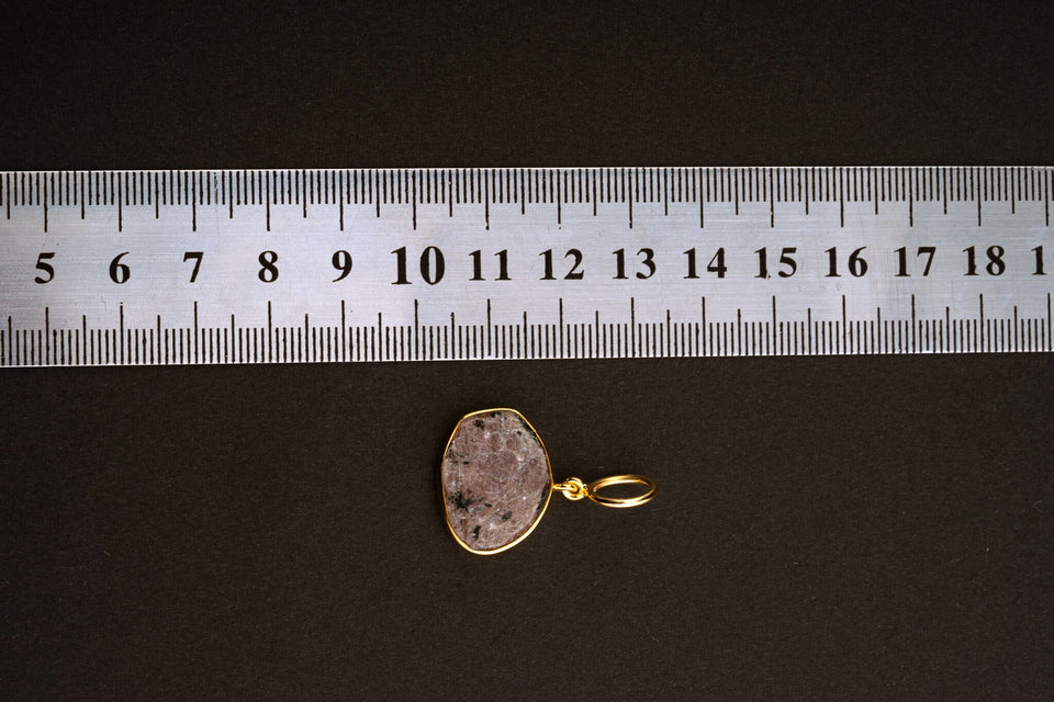Raw Indian Ruby pendant shown beside a ruler for scale, measuring approximately 2.5 cm total length including bail.