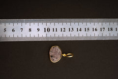 Raw Indian Ruby pendant shown beside a ruler for scale, measuring approximately 2.5 cm total length including bail.