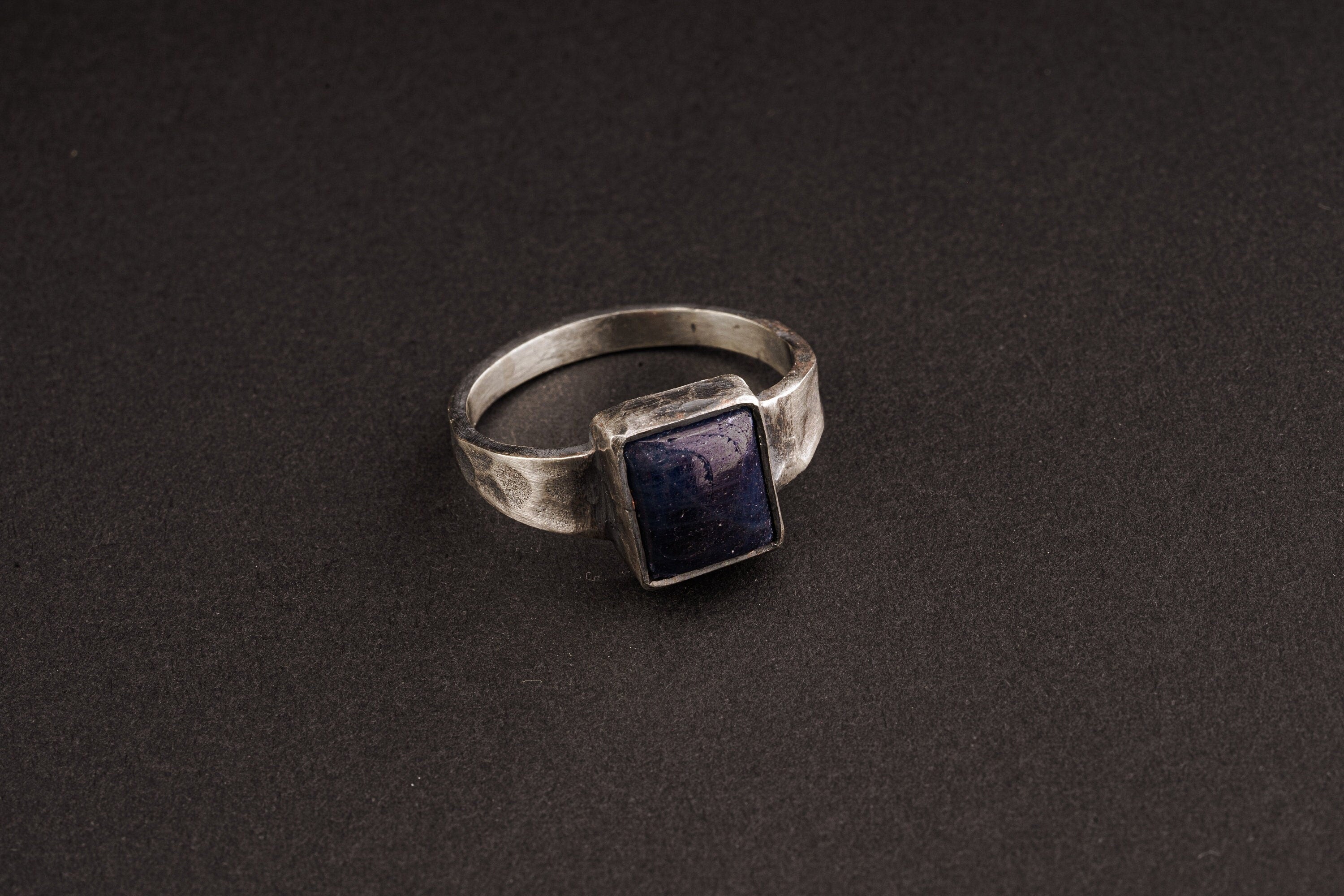 Tanzanite ring in oxidized 925 sterling silver with textured band and blue-violet gemstone set in a solid bezel.