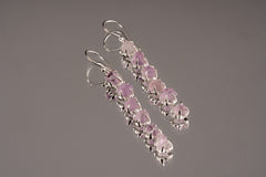 Raw Amethyst dangle earrings shown on a grey background with six purple stones and sterling silver claw settings.