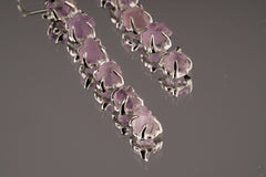 Close-up of six-stone Amethyst dangle earrings showing linked silver hoops and raw purple crystal texture.