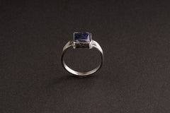 Tanzanite oxidized silver ring shown from the front, with strong textured band and refined blue-violet stone.