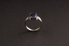 Tanzanite oxidized silver ring shown from the front, with strong textured band and refined blue-violet stone.