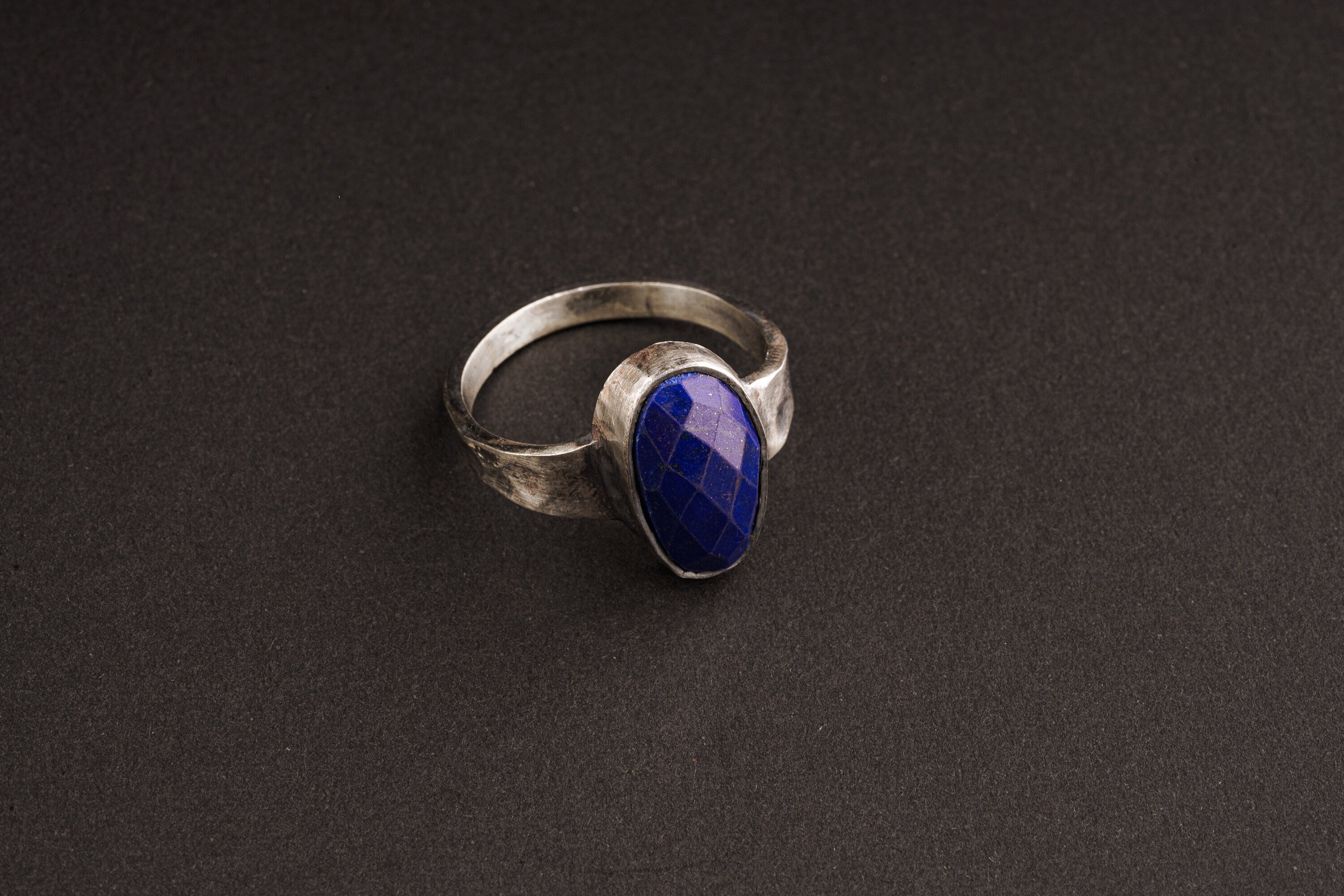 Lapis Lazuli ring in oxidized 925 sterling silver with hammered texture, open-back bezel, and deep blue gemstone.