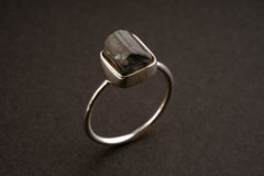 Watermelon Tourmaline sterling silver stack ring shown on a dark background, with rough crystal and fine silver band.