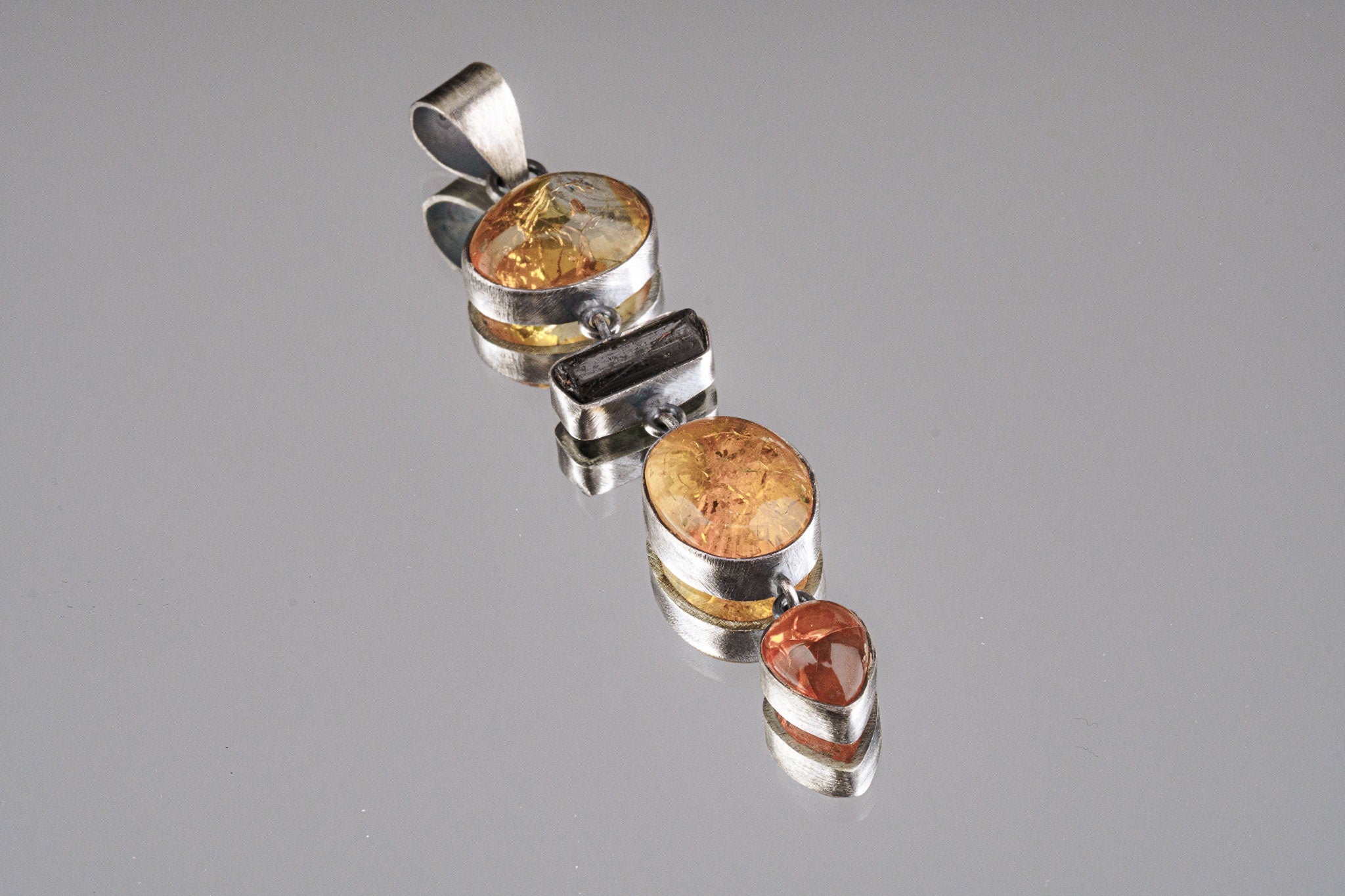 Ethiopian Opal Tourmaline Smoky Quartz Agate pendant shown on a white background with sterling silver and hinged gemstone layout.
