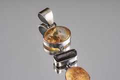 Close-up of polished Ethiopian Opal and handmade sterling silver bezel in a hinged statement pendant.