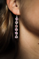 Six Stone Raw Amethyst dangle earring in 925 sterling silver shown worn on the ear with linked purple crystals.