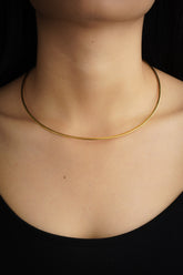 Gold-plated sterling silver open collar choker shown worn on a model as a minimal everyday necklace.