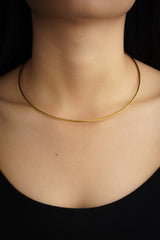Gold-plated sterling silver open collar choker shown worn on a model as a minimal everyday necklace.