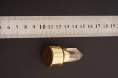 Rutilated Quartz capsule pendant shown beside a ruler for scale, with gold-plated brass body and crystal lid.