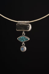Grounding Vision Stack Pendant shown worn on a model, with oxidized silver and three vertical gemstones.