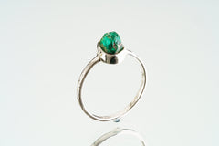 Side view of natural Emerald ring showing the raised green gemstone, handmade sterling silver setting, and solid band.