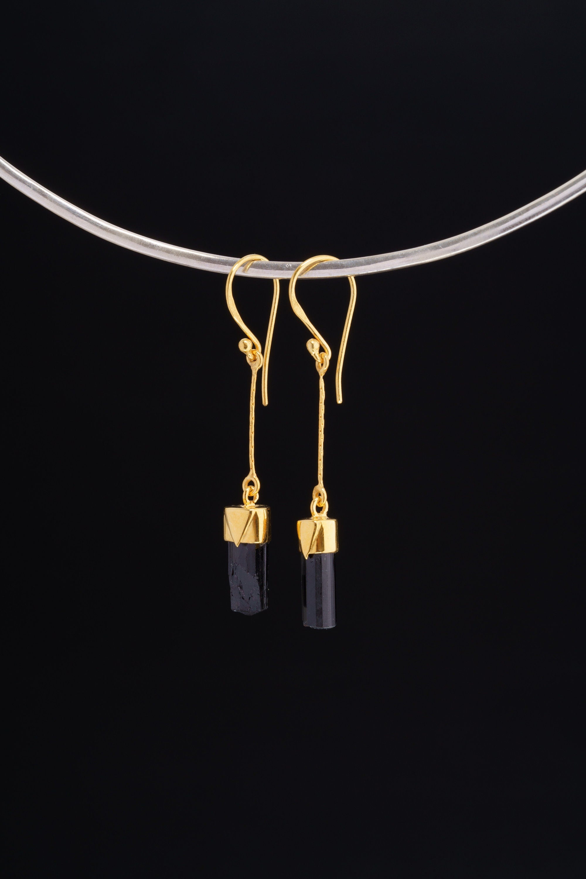 Black Tourmaline dangle earrings in gold-plated 925 sterling silver displayed on a silver choker with dark crystal drops.