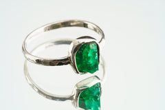 Side view of handmade Emerald ring showing the raised green gemstone, sturdy sterling silver band, and polished silver setting.