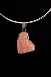 Rhodochrosite sterling silver pendant displayed on black background with pink natural stone and handmade setting.