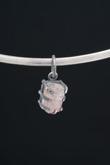 Watermelon Tourmaline pendant on black background shown on silver choker with compact oxidized claw setting.