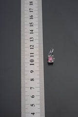 Watermelon Tourmaline pendant shown beside ruler for scale 1.5cm with pink-green crystal in oxidized silver claw setting.