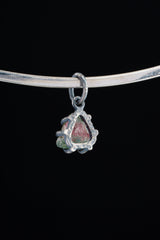 Watermelon Tourmaline Claw Pendant shown worn on black background with handmade oxidized sterling silver setting.
