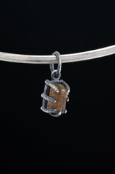Watermelon Tourmaline Claw Pendant on black background with oxidized sterling silver setting and natural pink-green stone.