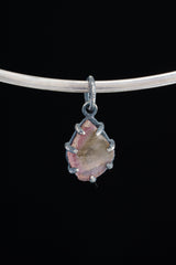 Watermelon Tourmaline pendant on black background showing compact oxidized silver claw setting and heart-centred stone.