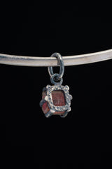 Pink Tourmaline Rubellite Claw Pendant on black background with handmade oxidized sterling silver frame.