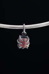 Pink Tourmaline Rubellite pendant shown worn on black background with compact oxidized silver claw setting.