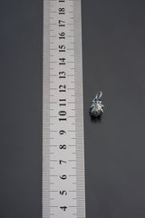Watermelon Tourmaline pendant shown beside ruler for scale 1.5cm with pink-green crystal in oxidized silver claw setting.
